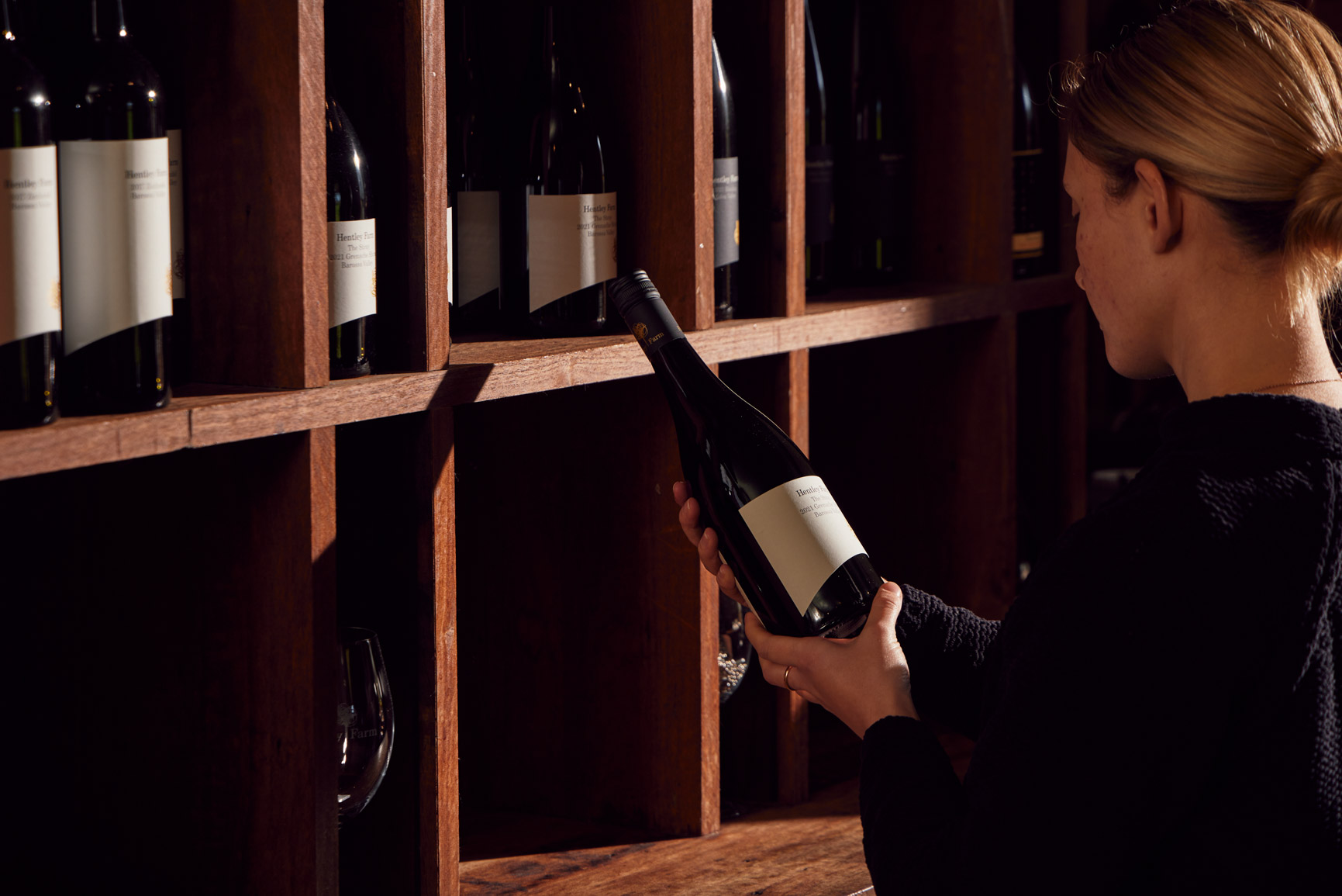 Selecting a wine bottle from the shelf Hentley Farm Cellar Door